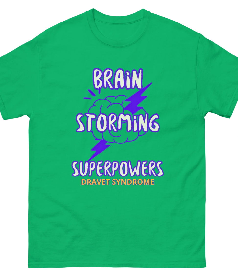 Green tshirt that has purple writing saying Brain Storming Superpowers with a brain having a lighting bolt through it. 